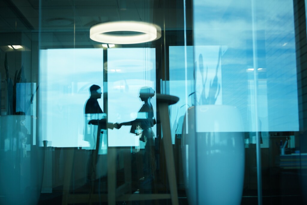 two people shaking hands on a corporate law deal